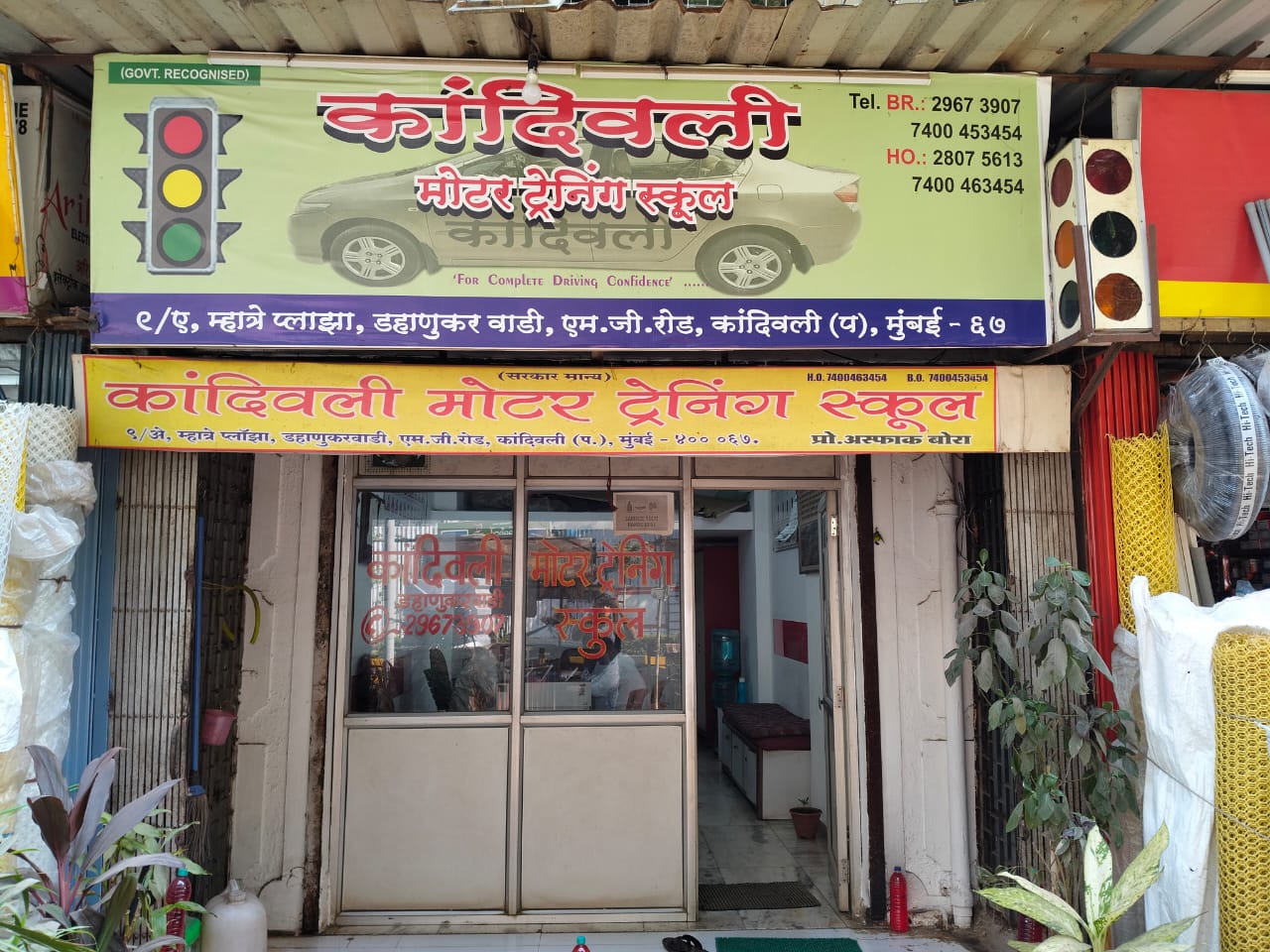 Kandivali Motor Training Institute building exterior with signboard and parked training cars